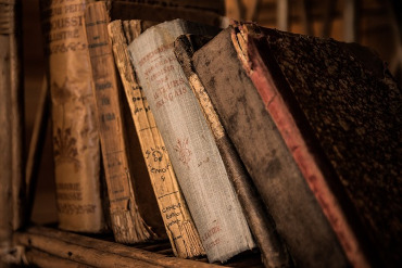 Libros antiguos y envejecidos en una estantería de madera